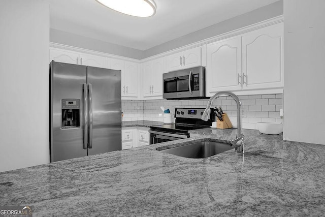 kitchen featuring decorative backsplash, appliances with stainless steel finishes, white cabinetry, and sink