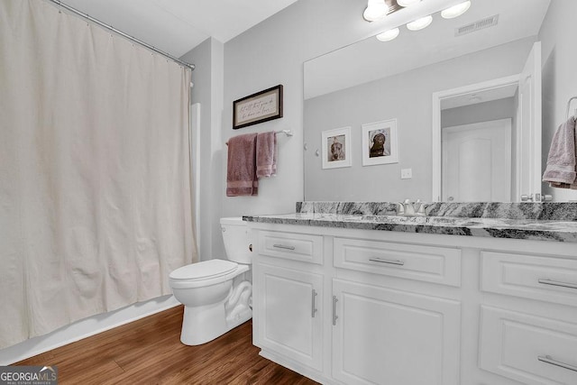 bathroom with vanity, wood-type flooring, and toilet