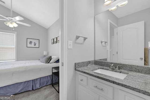 carpeted bedroom with ceiling fan, sink, and vaulted ceiling