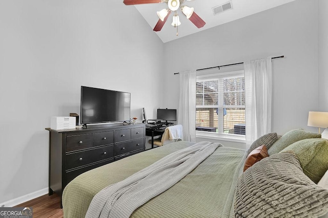 bedroom featuring ceiling fan, dark hardwood / wood-style flooring, and high vaulted ceiling