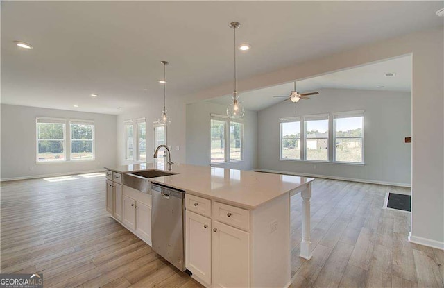 kitchen with dishwasher, sink, a healthy amount of sunlight, an island with sink, and white cabinets