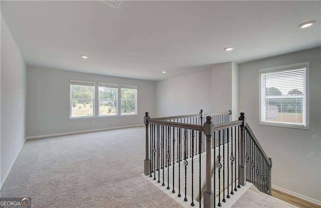 interior space with light colored carpet and a healthy amount of sunlight