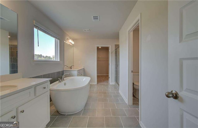 full bathroom featuring tile patterned floors, vanity, separate shower and tub, and toilet