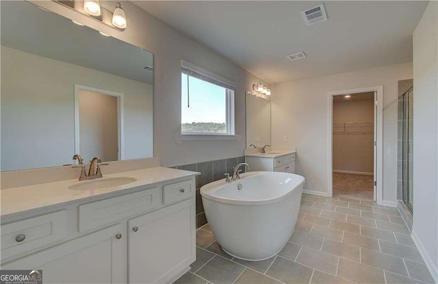 bathroom with tile patterned flooring, vanity, and independent shower and bath