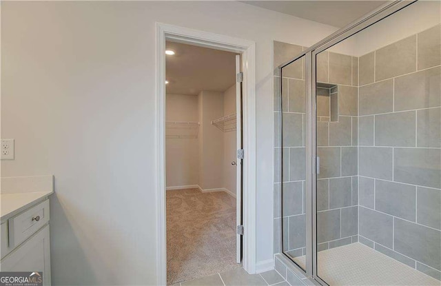 bathroom with tile patterned flooring, vanity, and a shower with shower door