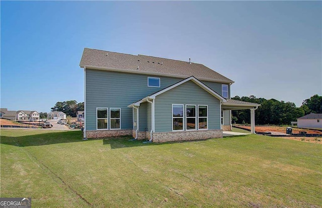 rear view of house featuring a lawn