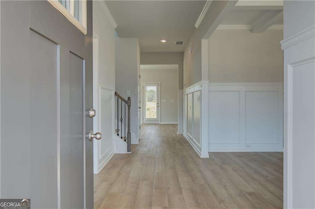 entryway with light wood-type flooring and crown molding