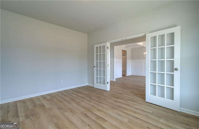 empty room with french doors and light hardwood / wood-style floors