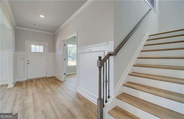 entrance foyer with light hardwood / wood-style flooring and ornamental molding