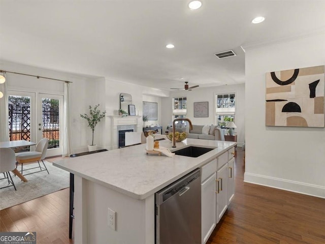 kitchen with white cabinetry, sink, dishwasher, and a kitchen island with sink