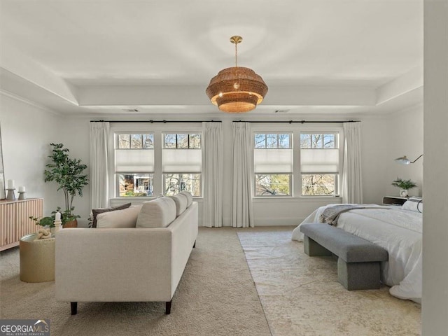 carpeted bedroom with a tray ceiling