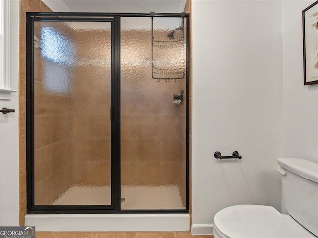 bathroom with tile patterned floors, toilet, and walk in shower