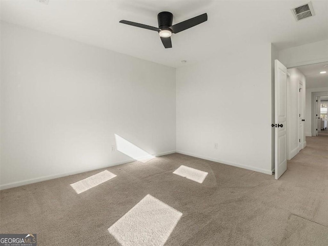 empty room with ceiling fan and light colored carpet