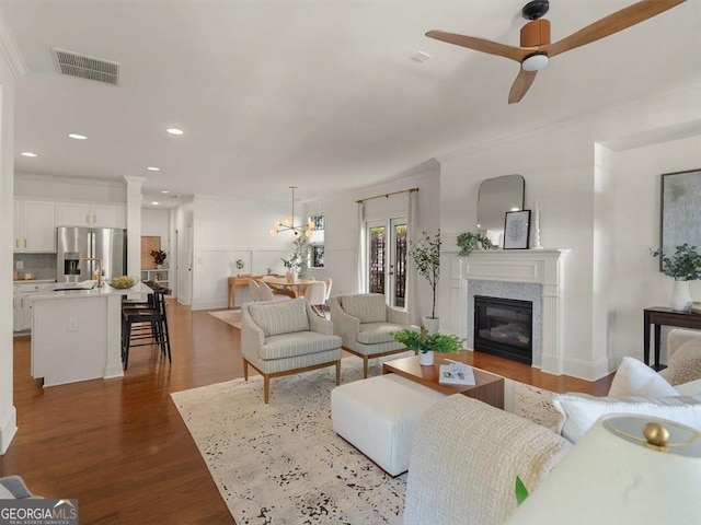 living room featuring hardwood / wood-style flooring, ornamental molding, sink, and ceiling fan