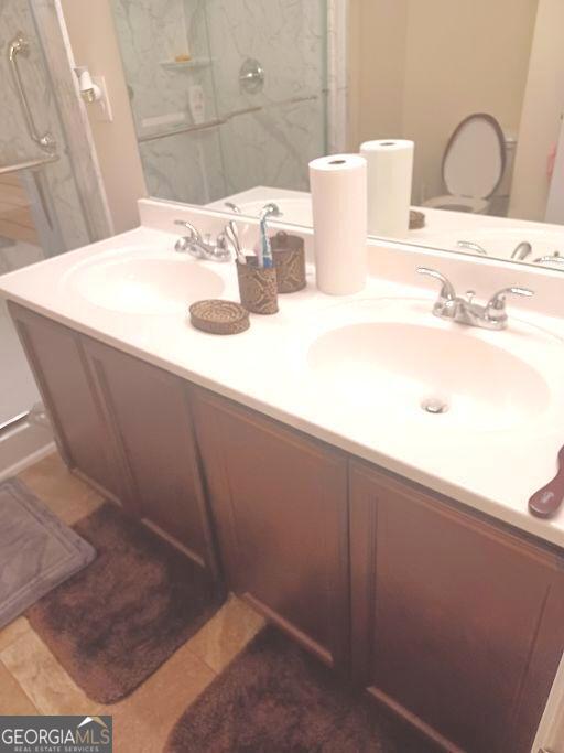 bathroom featuring a tile shower, vanity, and tile patterned floors