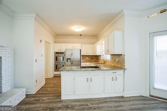 kitchen with light stone countertops, white cabinets, appliances with stainless steel finishes, decorative backsplash, and sink