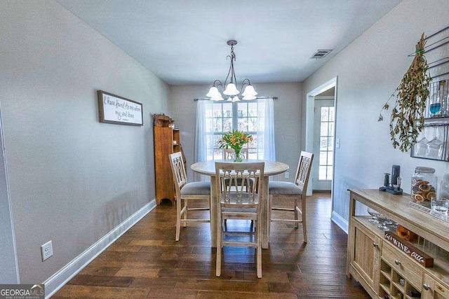 dining area with a notable chandelier and dark wood-type flooring