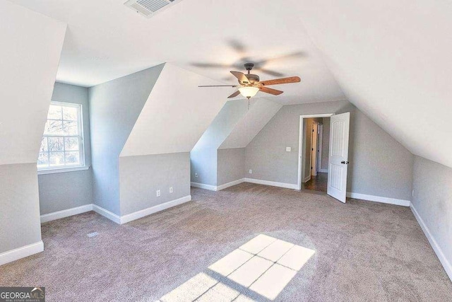 additional living space featuring ceiling fan, light colored carpet, and vaulted ceiling