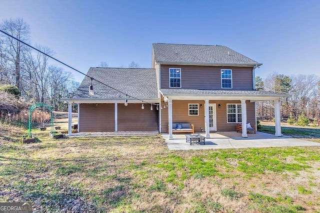 back of house featuring a lawn and a patio area