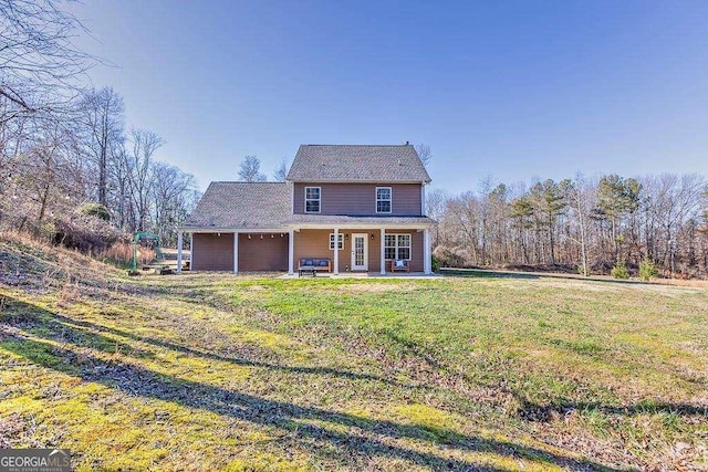 rear view of property with a lawn and a garage