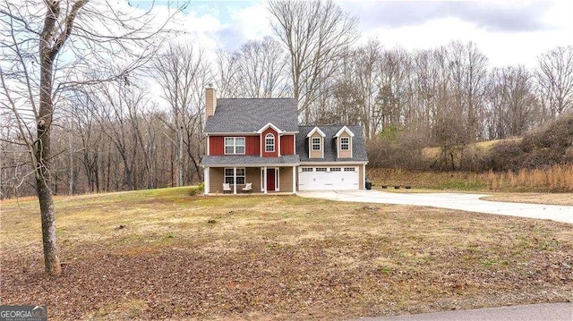 view of front of house featuring a garage, covered porch, and a front lawn