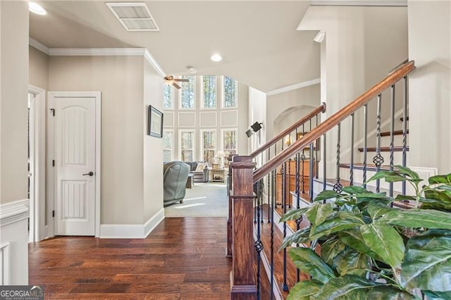 interior space with a towering ceiling, hardwood / wood-style flooring, and ornamental molding