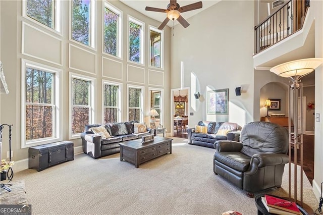 living room featuring carpet flooring, a high ceiling, and ceiling fan