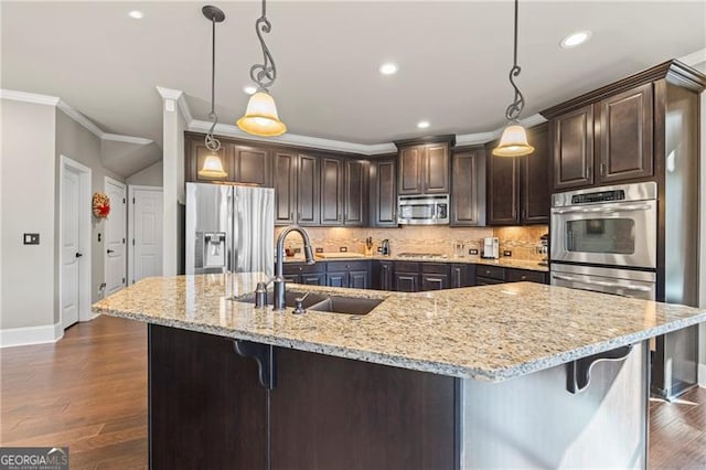 kitchen with dark brown cabinetry, sink, hanging light fixtures, a spacious island, and appliances with stainless steel finishes