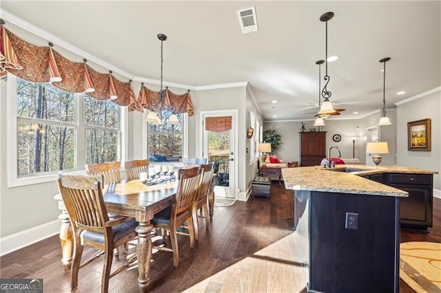 dining space with crown molding, sink, ceiling fan with notable chandelier, and dark hardwood / wood-style floors