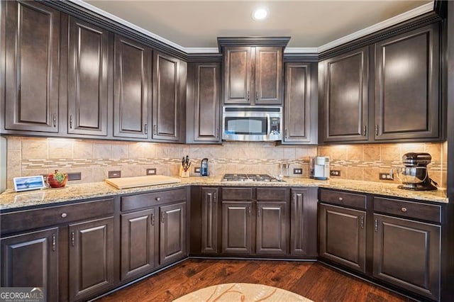 kitchen with dark brown cabinetry, stainless steel appliances, dark hardwood / wood-style floors, and crown molding