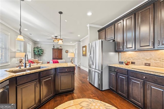 kitchen featuring pendant lighting, dark brown cabinetry, crown molding, and appliances with stainless steel finishes