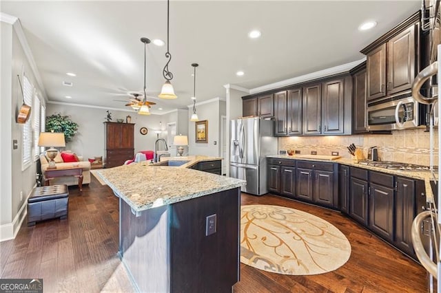 kitchen with sink, pendant lighting, a kitchen island with sink, dark brown cabinets, and appliances with stainless steel finishes