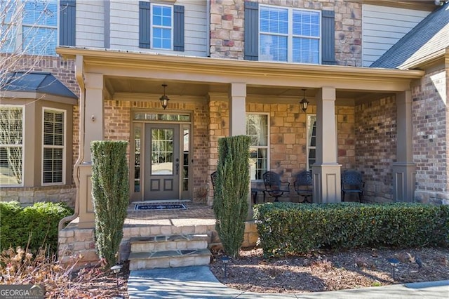 view of exterior entry featuring covered porch