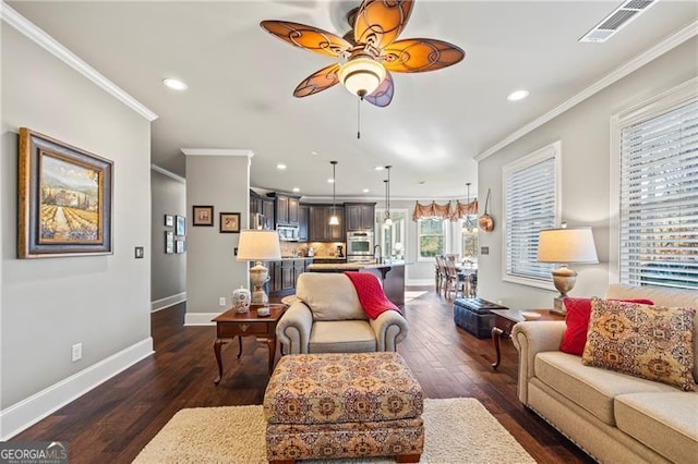 living room with ceiling fan, dark hardwood / wood-style flooring, and ornamental molding