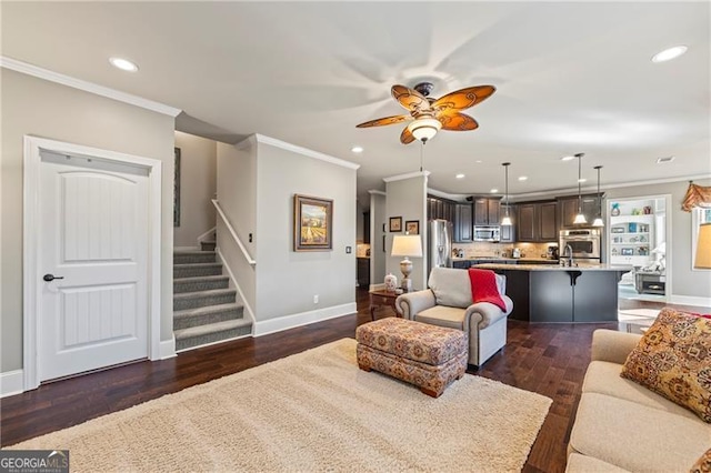 living room with ceiling fan, dark wood-type flooring, and ornamental molding