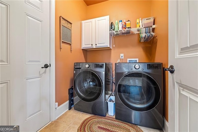 laundry area with cabinets, light tile patterned floors, and independent washer and dryer