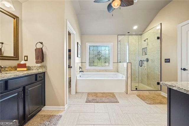 full bathroom with ceiling fan, separate shower and tub, vaulted ceiling, toilet, and vanity