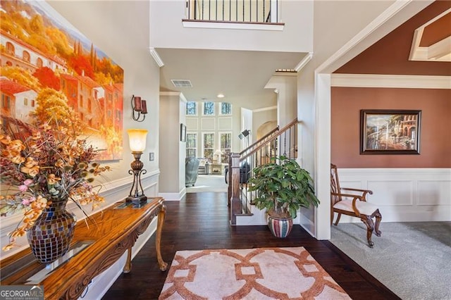 entrance foyer featuring dark wood-type flooring and ornamental molding