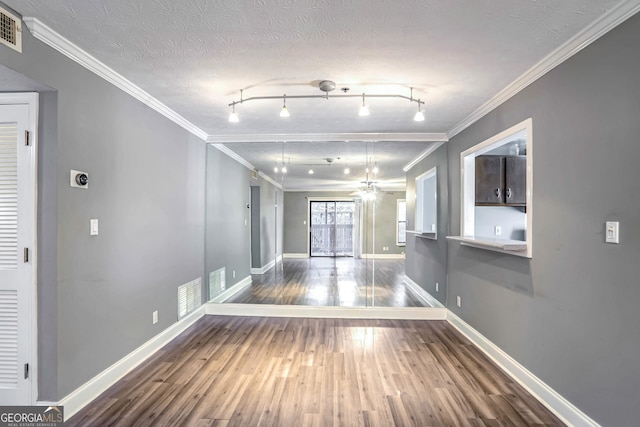 corridor featuring hardwood / wood-style floors, a textured ceiling, track lighting, and crown molding