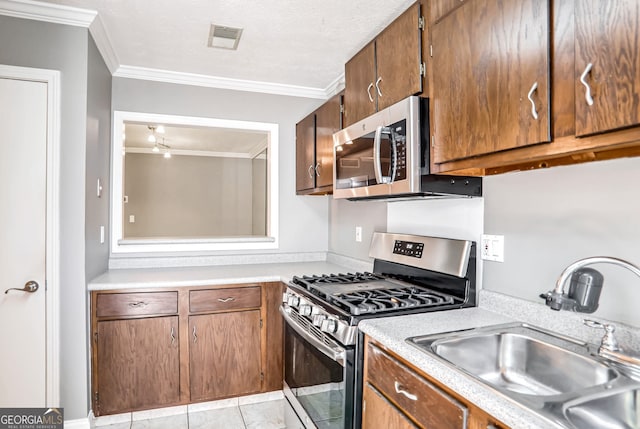 kitchen with light tile patterned flooring, sink, ornamental molding, and stainless steel appliances