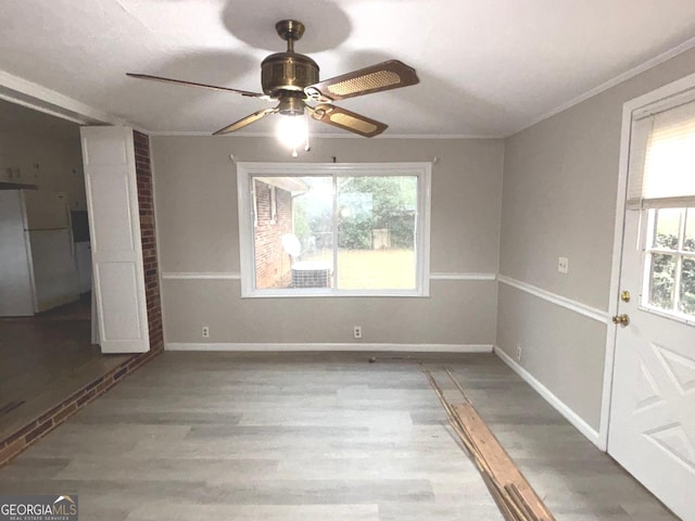 empty room featuring a textured ceiling, hardwood / wood-style flooring, ceiling fan, and ornamental molding