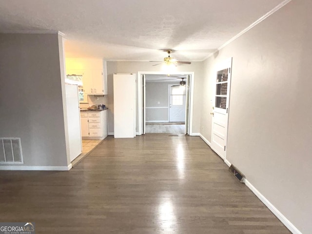 corridor featuring a textured ceiling, crown molding, and dark wood-type flooring