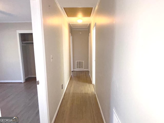 hallway featuring wood-type flooring and crown molding