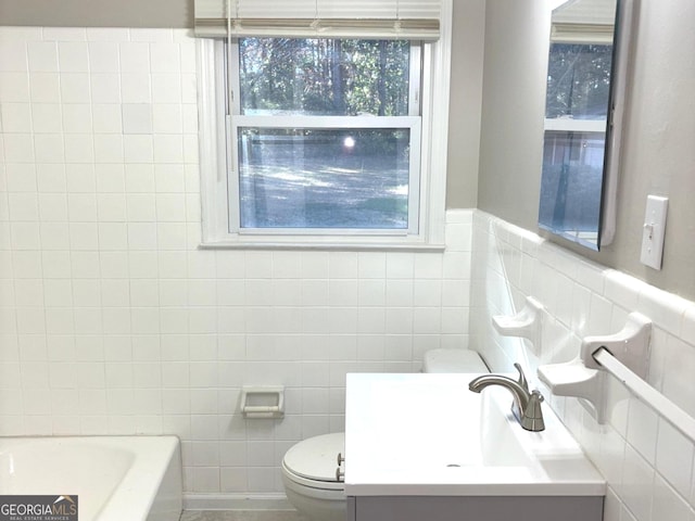 bathroom with vanity, toilet, a tub, and tile walls