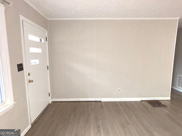 foyer with dark hardwood / wood-style floors and crown molding