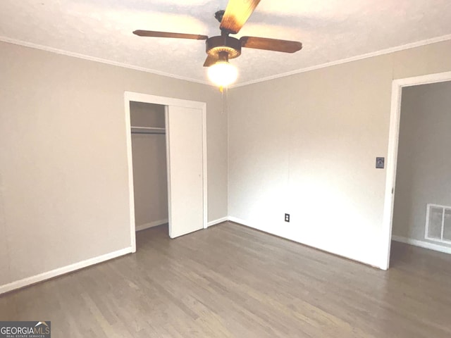 unfurnished bedroom featuring ceiling fan, dark hardwood / wood-style flooring, crown molding, and a textured ceiling