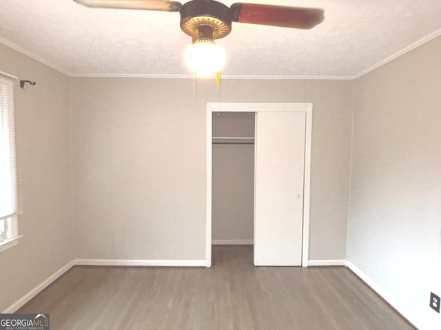 unfurnished bedroom featuring wood-type flooring, a textured ceiling, ceiling fan, and ornamental molding