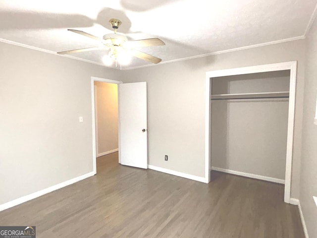 unfurnished bedroom featuring crown molding, ceiling fan, dark hardwood / wood-style floors, a textured ceiling, and a closet