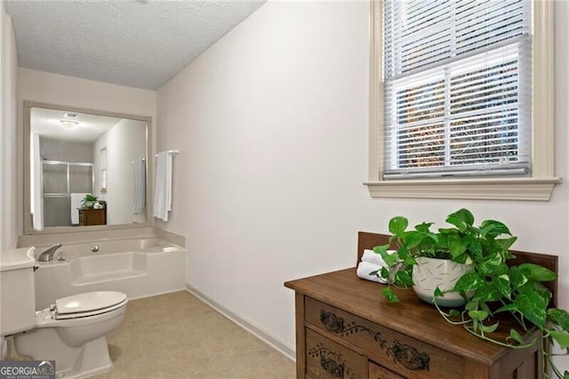 bathroom with toilet, a textured ceiling, and a tub