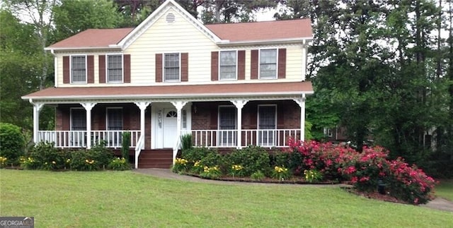 view of front of house with a porch and a front yard